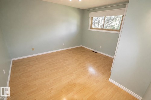 Room featuring light wood-finish flooring, a double window with wood framing, white baseboards, and light-colored walls - 4510 Lakeshore Dr, St. Paul Town, AB - Indoor Photo Showing Other Room