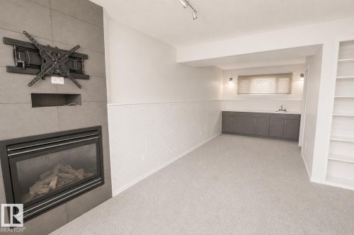 Fireplace with gray tile surround and integrated media niche - 4510 Lakeshore Dr, St. Paul Town, AB - Indoor With Fireplace
