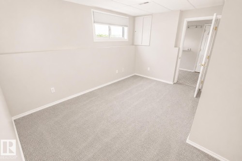 Room featuring light gray wall paint, gray carpeting, white baseboards, and a single window with a roller shade - 4510 Lakeshore Dr, St. Paul Town, AB - Indoor Photo Showing Other Room