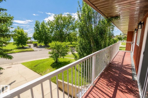Private balcony featuring wood-finish decking and white metal railings - 4510 Lakeshore Dr, St. Paul Town, AB - Outdoor With Exterior