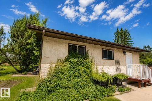 Exterior facade featuring textured stucco, multiple windows, and a raised entry with white railings - 4510 Lakeshore Dr, St. Paul Town, AB - Outdoor