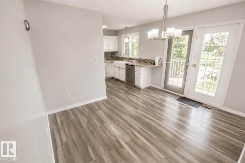 Dining area featuring wood-finish flooring, a contemporary chandelier, and French patio doors opening to a balcony - 4510 Lakeshore Dr, St. Paul Town, AB - Indoor