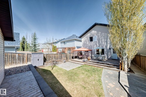 Expansive backyard featuring a multi-level deck, paved patio areas, a storage shed, and raised garden beds - 5333 Terwillegar Boulevard, Edmonton, AB - Outdoor With Deck Patio Veranda With Exterior