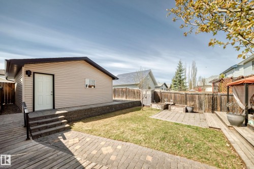 Detached garage structure featuring light-toned siding, a dark roof, and a white entry door - 5333 Terwillegar Boulevard, Edmonton, AB - Outdoor With Deck Patio Veranda With Exterior