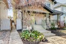 Front exterior featuring a covered porch with stone-clad columns, a wood-finish railing, and concrete steps - 5333 Terwillegar Boulevard, Edmonton, AB  - Outdoor With Deck Patio Veranda 