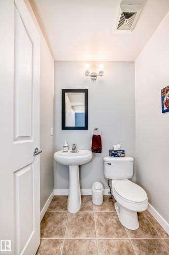Powder room featuring a pedestal sink, toilet, and a wall-mounted light fixture - 5333 Terwillegar Boulevard, Edmonton, AB - Indoor Photo Showing Bathroom