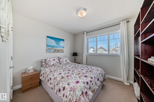 Spacious bedroom featuring a large window, built-in shelving, carpet flooring, and a flush-mount ceiling light - 5333 Terwillegar Boulevard, Edmonton, AB - Indoor Photo Showing Bedroom