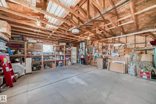 Spacious garage with exposed wood beam ceiling, concrete flooring, and ample built-in shelving - 5333 Terwillegar Boulevard, Edmonton, AB - Indoor