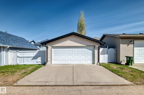 Detached garage with horizontal siding, a white panel garage door, and a concrete driveway - 5333 Terwillegar Boulevard, Edmonton, AB - Outdoor With Exterior