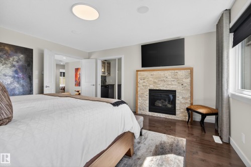 Interior room featuring dark wood-finish flooring and light-toned walls - 2760 Watcher Way, Edmonton, AB - Indoor Photo Showing Bedroom With Fireplace