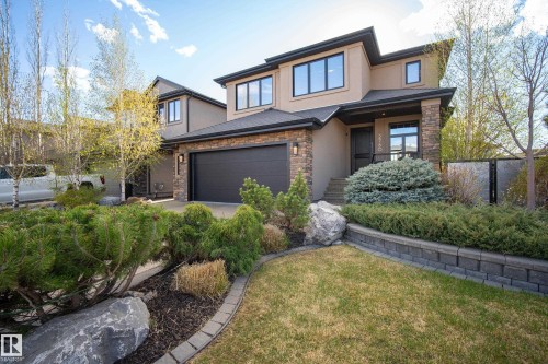Contemporary stucco and stone-clad exterior with a dark garage door - 2760 Watcher Way, Edmonton, AB - Outdoor