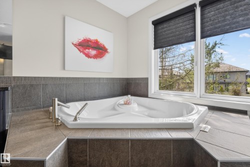 Corner soaking tub with brushed nickel fixtures - 2760 Watcher Way, Edmonton, AB - Indoor Photo Showing Bathroom