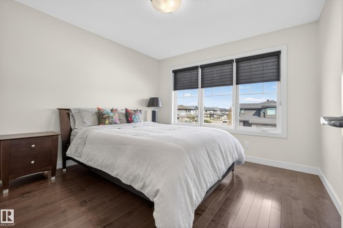 Bedroom featuring rich wood-finish flooring and light-toned walls - 2760 Watcher Way, Edmonton, AB - Indoor Photo Showing Bedroom