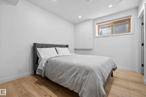 Bedroom featuring light wood-finish flooring, recessed lighting, and a window with blinds - 2760 Watcher Way, Edmonton, AB - Indoor Photo Showing Bedroom