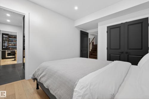 Recessed lighting illuminates this room, featuring light wood-finish flooring and a doorway leading to a wet bar with built-in cabinetry - 2760 Watcher Way, Edmonton, AB - Indoor Photo Showing Bedroom