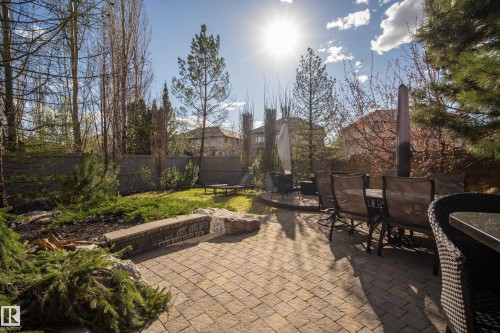 Expansive paver patio with a stone retaining wall and integrated landscaping - 2760 Watcher Way, Edmonton, AB - Outdoor