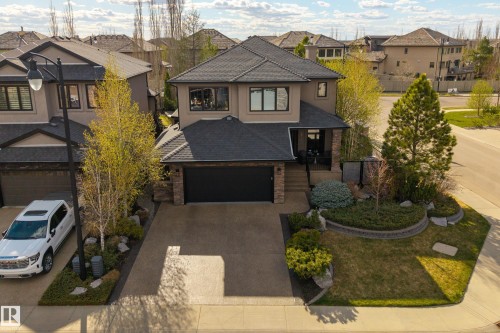 Contemporary two-story residence featuring a stone and stucco exterior, an attached two-car garage, and a concrete driveway - 2760 Watcher Way, Edmonton, AB - Outdoor With Facade