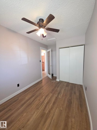 Room featuring wood-finish flooring, light grey walls, and a ceiling fan with integrated lighting - 16 South Ram Crescent, Devon, AB - Indoor Photo Showing Other Room