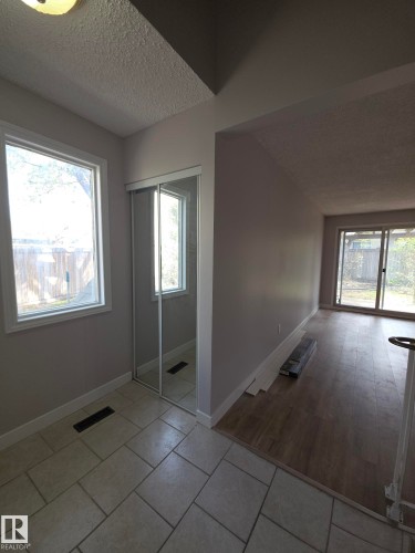 Entryway featuring a sliding mirrored closet door and tile flooring - 16 South Ram Crescent, Devon, AB - Indoor Photo Showing Other Room