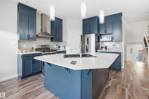Modern kitchen featuring a large central island with a white countertop and integrated sink - 2284 Chokecherry Close, Edmonton, AB - Indoor Photo Showing Kitchen With Upgraded Kitchen