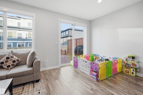 Open-concept living area featuring wood-finish flooring and neutral wall tones - 2284 Chokecherry Close, Edmonton, AB - Indoor