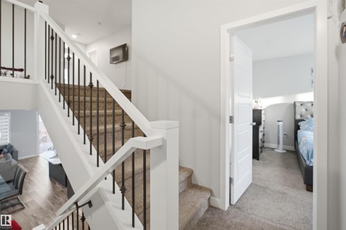 Staircase featuring white newel posts, white handrails, and black metal balusters - 2284 Chokecherry Close, Edmonton, AB - Indoor Photo Showing Other Room
