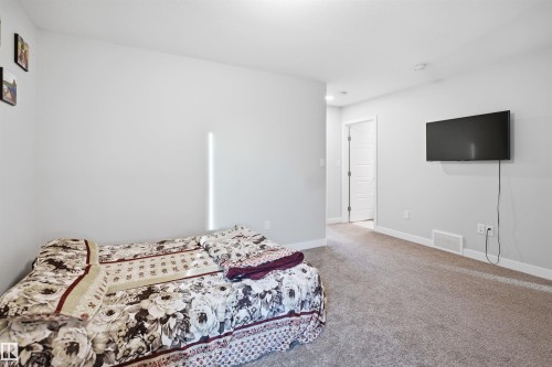 Spacious room featuring light gray wall paint, white trim, and neutral carpet flooring - 2284 Chokecherry Close, Edmonton, AB - Indoor Photo Showing Bedroom