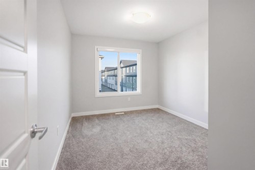 Neutral-toned room featuring a single window and plush gray carpeting - 2284 Chokecherry Close, Edmonton, AB - Indoor Photo Showing Other Room
