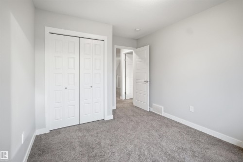 Neutral-toned room featuring a soft gray carpet, white baseboards, and light gray walls - 2284 Chokecherry Close, Edmonton, AB - Indoor