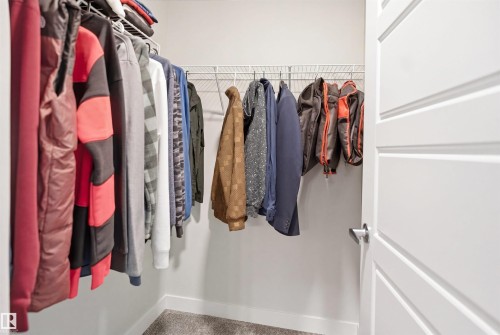 Walk-in closet featuring wire shelving, wire hanging rods, and light gray wall paint - 2284 Chokecherry Close, Edmonton, AB - Indoor With Storage