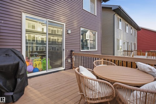 Expansive wood-finish deck with wooden railing and modern wall sconce - 2284 Chokecherry Close, Edmonton, AB - Outdoor With Deck Patio Veranda With Exterior