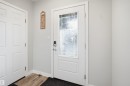 Entry door with decorative glass inserts, modern smart lock hardware, and bright white trim - 2284 Chokecherry Close, Edmonton, AB  - Indoor Photo Showing Other Room 