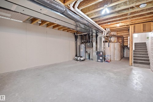 Unfinished basement featuring exposed ceiling joists, concrete flooring, and an open layout - 2284 Chokecherry Close, Edmonton, AB - Indoor Photo Showing Basement