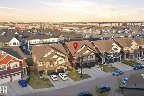 Craftsman-style home featuring a two-car garage, light-colored siding, and a dark brown shingle roof - 2284 Chokecherry Close, Edmonton, AB - Outdoor