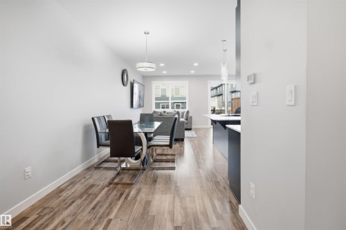 Open-concept living space featuring wood-finish flooring, recessed lighting, and a modern kitchen island with pendant lighting - 2284 Chokecherry Close, Edmonton, AB - Indoor Photo Showing Dining Room