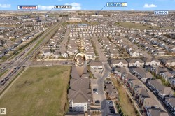 Aerial view showcasing a residential neighborhood with numerous homes featuring dark roofs - 