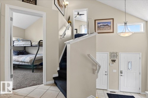The entryway features two white doors, a chandelier, and a transom window above - 3518 18 Street, Edmonton, AB - Indoor Photo Showing Other Room