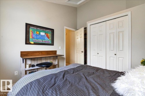 This room features light-colored walls, carpeted flooring, and a built-in wooden desk - 3518 18 Street, Edmonton, AB - Indoor Photo Showing Bedroom