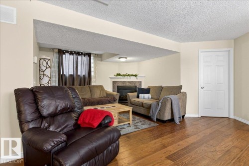 The living area features hardwood floors and a fireplace with a mantel - 3518 18 Street, Edmonton, AB - Indoor Photo Showing Living Room With Fireplace