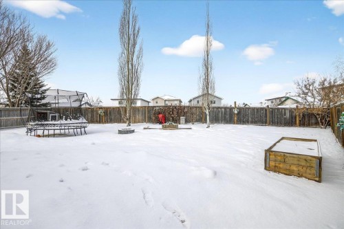 The property features a spacious backyard with a wooden fence and a raised garden bed - 3518 18 Street, Edmonton, AB - Outdoor