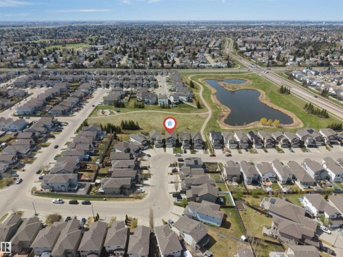 Aerial perspective showcasing a residential neighborhood with a prominent central pond feature - 2138 32B Street, Edmonton, AB - Outdoor With View