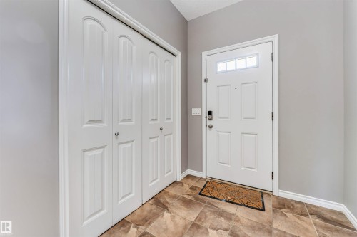 Entryway featuring a white paneled door with transom windows, a smart lock, and neutral-toned walls - 2138 32B Street, Edmonton, AB - Indoor Photo Showing Other Room