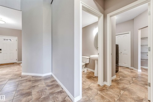 Entryway featuring durable tile flooring, a white paneled front door with decorative glass inserts, and neutral wall tones - 2138 32B Street, Edmonton, AB - Indoor Photo Showing Other Room