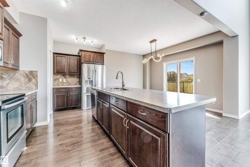 Kitchen featuring a central island with an undermount sink and a gooseneck faucet - 2138 32B Street, Edmonton, AB - Indoor Photo Showing Kitchen With Stainless Steel Kitchen With Upgraded Kitchen