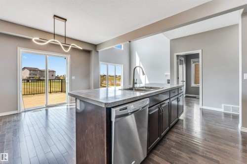 Kitchen island with integrated stainless steel dishwasher and double basin sink - 2138 32B Street, Edmonton, AB - Indoor Photo Showing Kitchen With Double Sink