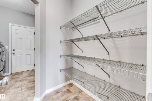 Corner pantry featuring multiple wire shelving units, light gray walls, and tile flooring - 2138 32B Street, Edmonton, AB - Indoor With Storage