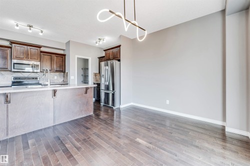 Open-concept kitchen and dining area featuring rich wood-finish flooring - 2138 32B Street, Edmonton, AB - Indoor Photo Showing Kitchen