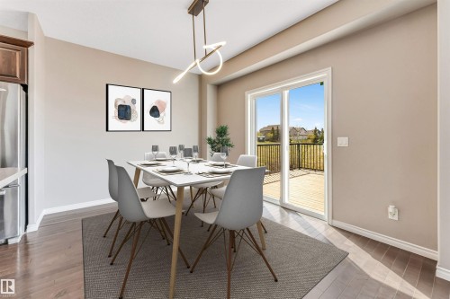 Dining area featuring wood-finish flooring, a contemporary linear light fixture, and a sliding glass door - 2138 32B Street, Edmonton, AB - Indoor Photo Showing Dining Room