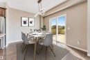 Dining area featuring wood-finish flooring, a contemporary linear light fixture, and a sliding glass door - 2138 32B Street, Edmonton, AB  - Indoor Photo Showing Dining Room 
