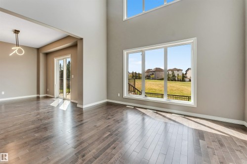 Spacious interior room featuring high ceilings, wood-finish flooring, and ample natural light from large windows - 2138 32B Street, Edmonton, AB - Indoor Photo Showing Other Room